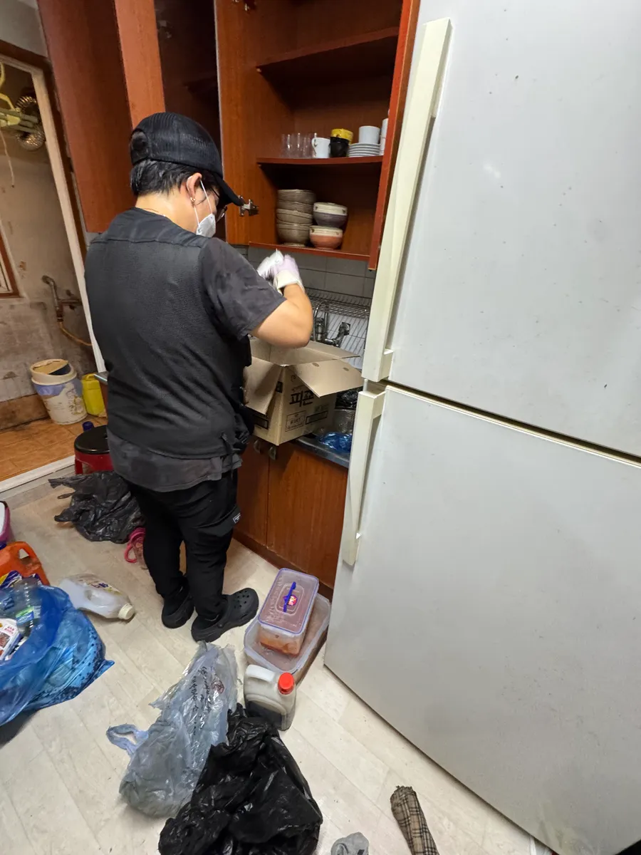 안산 유품정리 작업 전, 냉장고 안 내용물을 확인하며 분류하는 모습