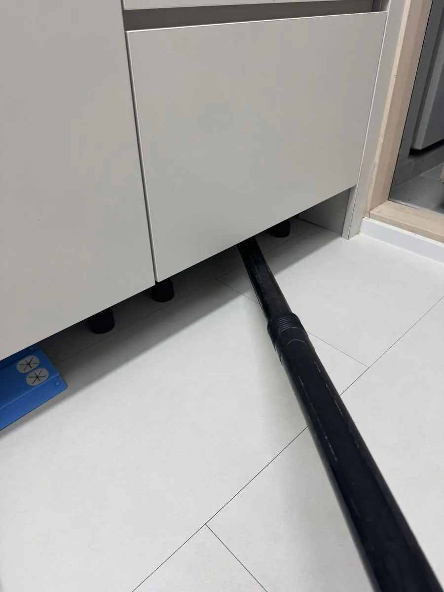 안양 침수청소 중 걸레받이 틈으로 호스를 넣어 작업하는 모습