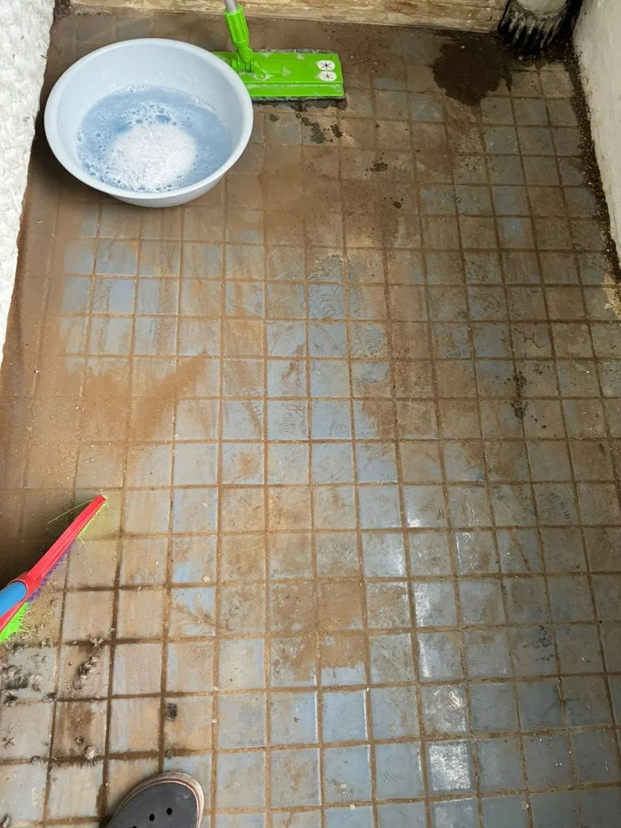 부천 고독사청소 중 물을 받아 베란다 타일을 밀대로 닦는 모습
