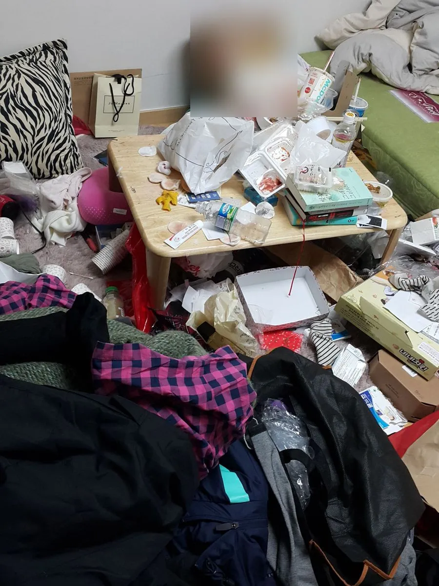 경기 광주 쓰레기집 청소 작업 전 상 위와 주변에 생활용품과 옷가지가 쌓인 모습