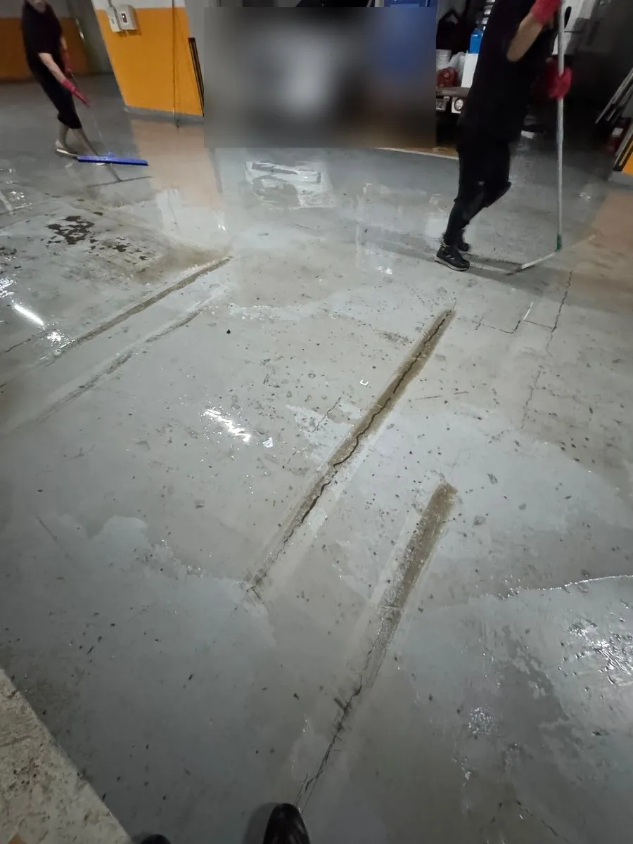 남동공단 침수청소 중 밀대로 흙탕물을 밀어 내는 모습