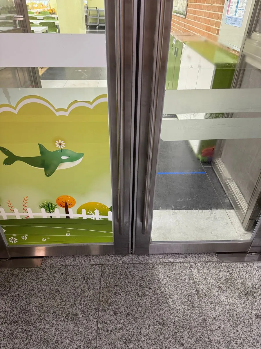 수원 학교청소 중 그림 시트지를 일부 떼어 낸 유리 출입문