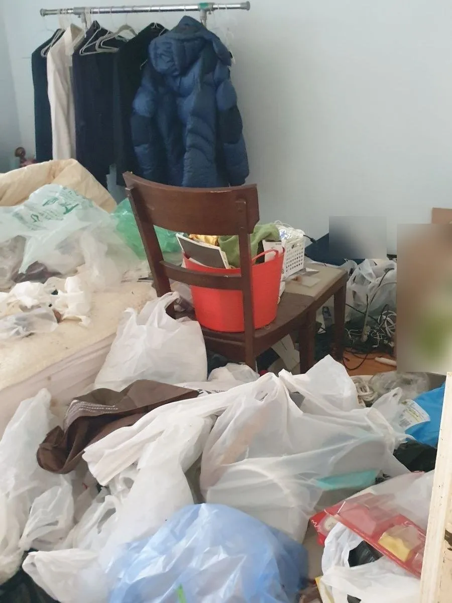 수원 쓰레기집 청소 작업 전 침대 위와 바닥에 비닐봉지가 쌓인 작은 방